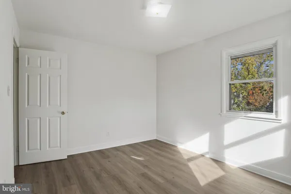 a view of an empty room with a fireplace and a window