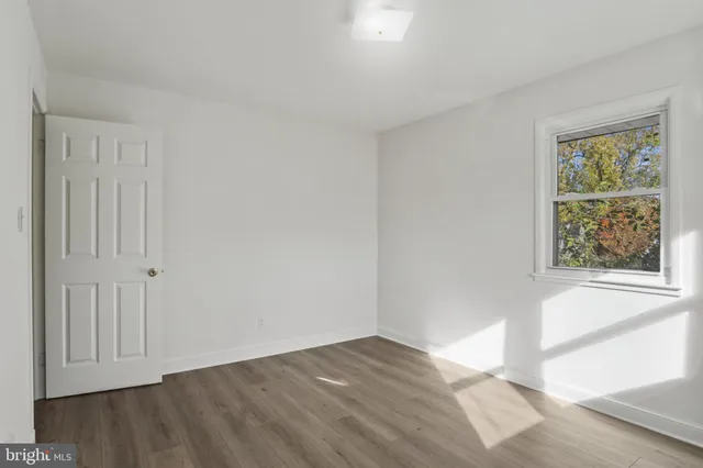 a view of an empty room with a fireplace and a window