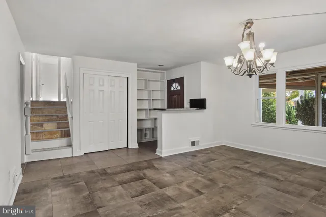 a view of a livingroom with a chandelier fan and windows