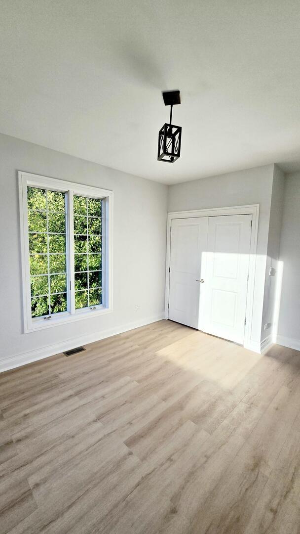 5936 West Maple Avenue Berkeley, IL 60163 - Photo 15 of 25 a view of an empty room with a window and wooden floor