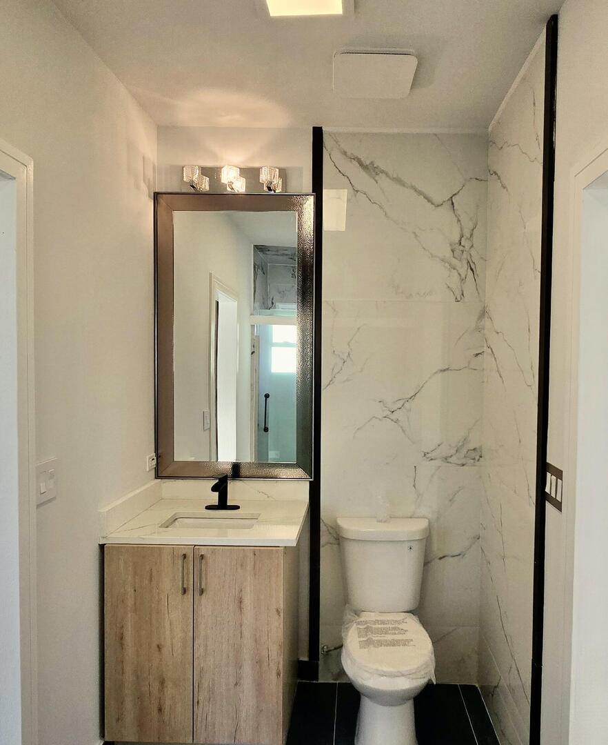 5936 West Maple Avenue Berkeley, IL 60163 - Photo 21 of 25 a bathroom with a granite countertop sink toilet and a mirror