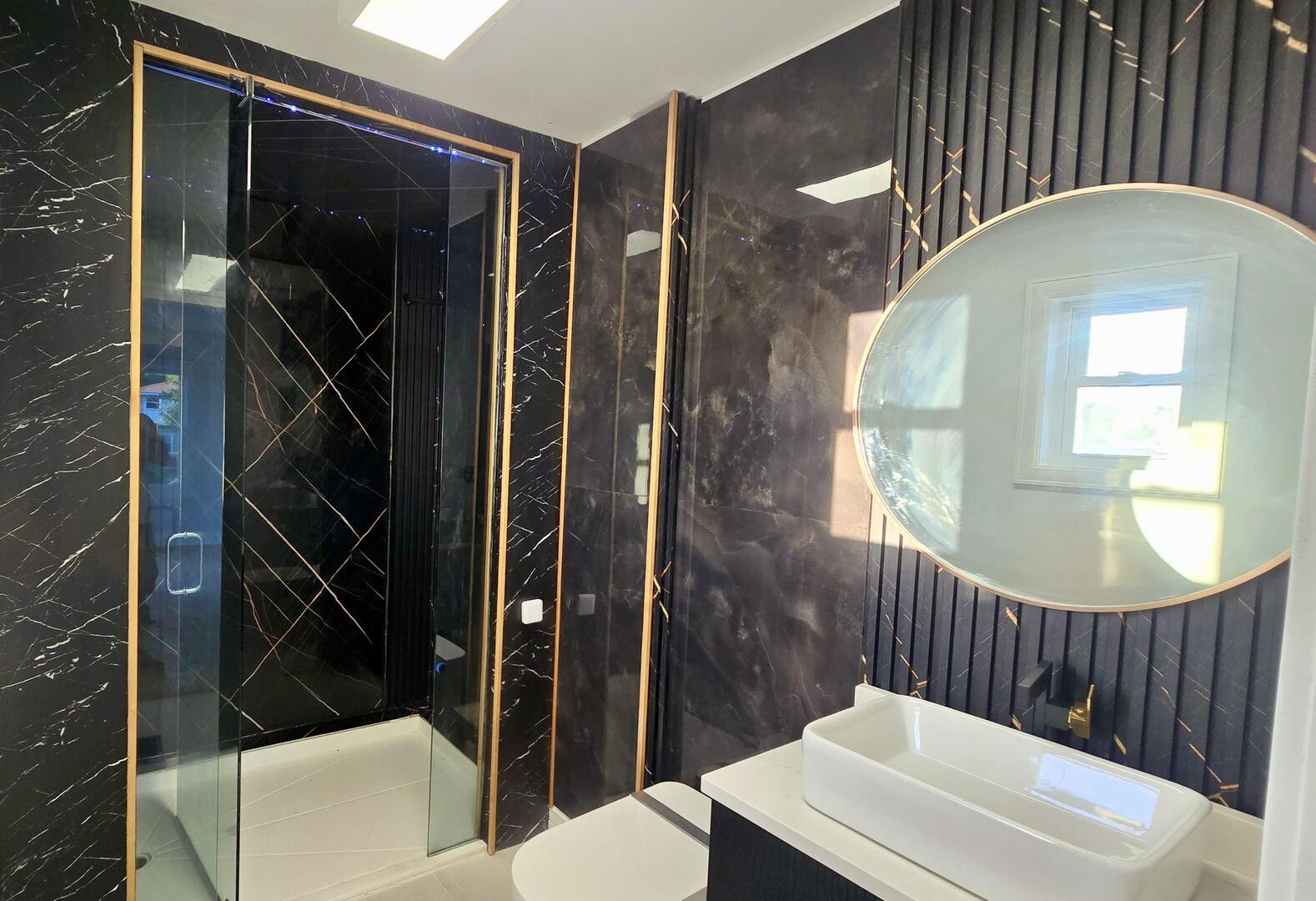 5936 West Maple Avenue Berkeley, IL 60163 - Photo 10 of 25 a bathroom with a sink a mirror a vanity and a shower