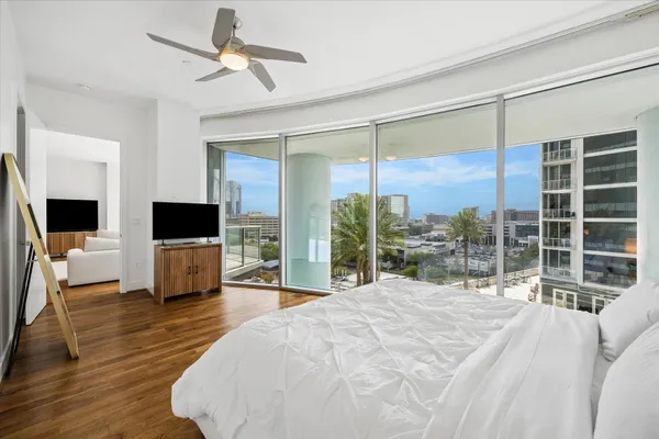 a large bedroom with a bed large window and a flat screen tv