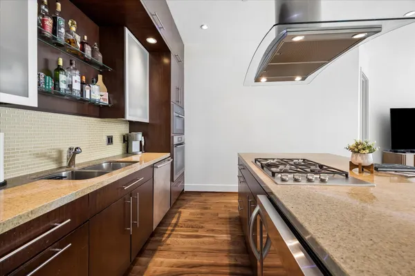 a kitchen with stainless steel appliances granite countertop a sink stove and cabinets