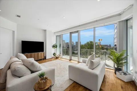 a living room with furniture large window and a flat screen tv