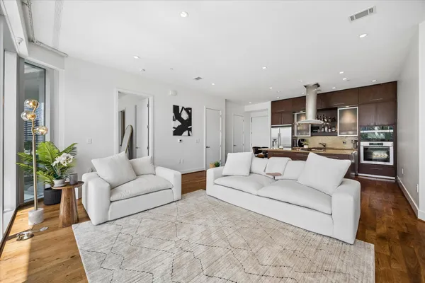 a living room with furniture white walls and kitchen view