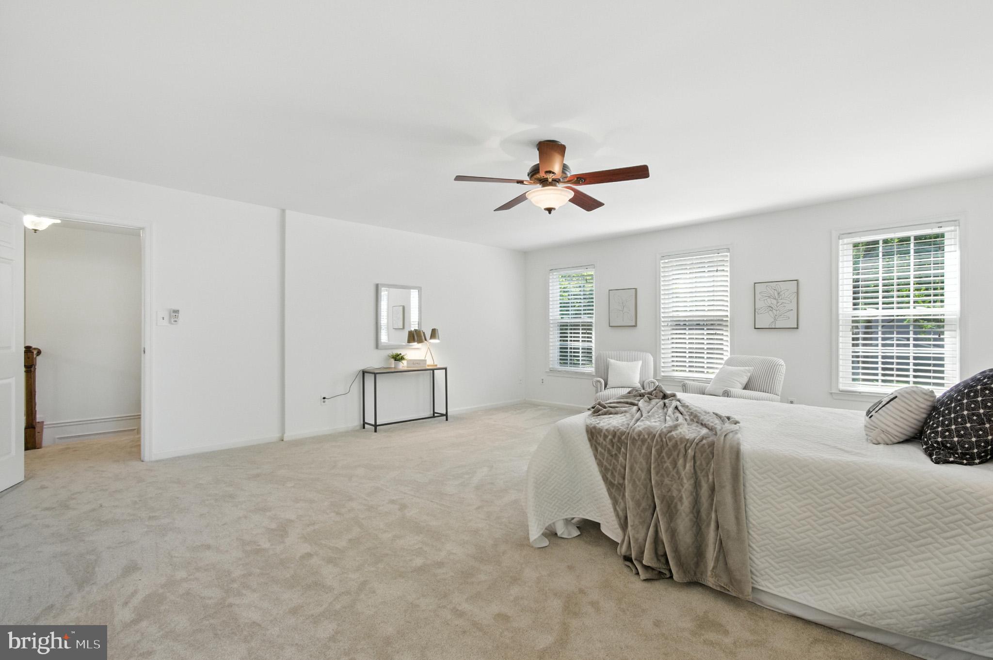 6030 Watch Chain Way Columbia, MD 21044 - Photo 61 of 90 a spacious bedroom with a bed a window and a chandelier