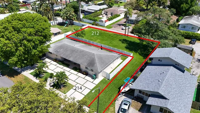 an aerial view of a tennis ground and a cars park side of the road
