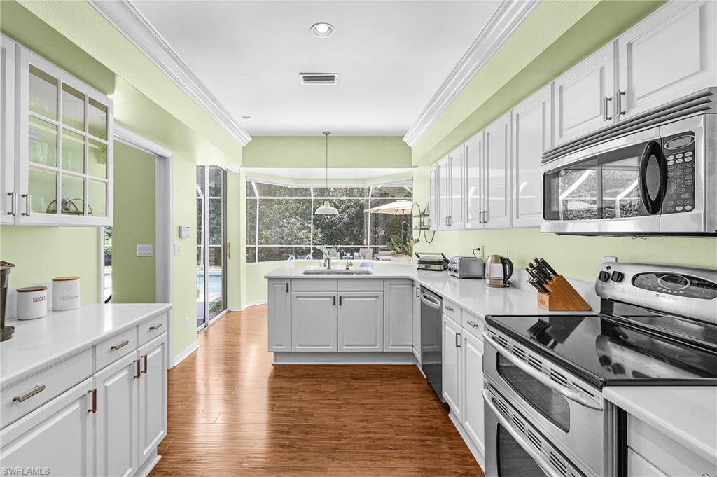 258 Monterey Drive Naples, FL 34119 - Photo 16 of 36 a kitchen with stainless steel appliances a stove sink and cabinets