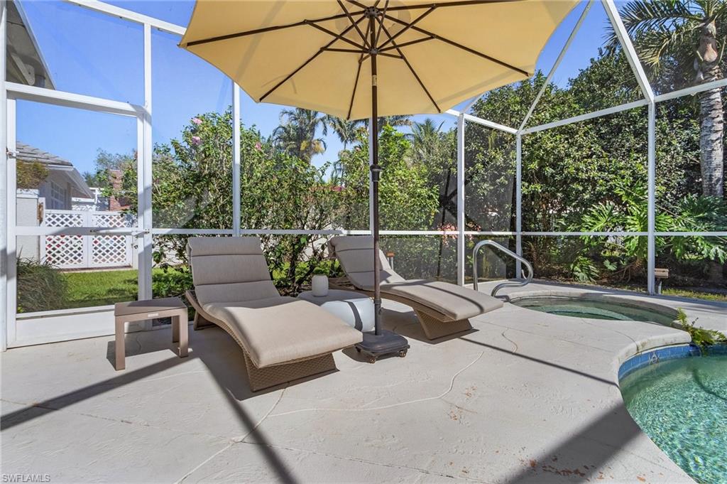 258 Monterey Drive Naples, FL 34119 - Photo 23 of 36 a view of a backyard with couches and umbrella