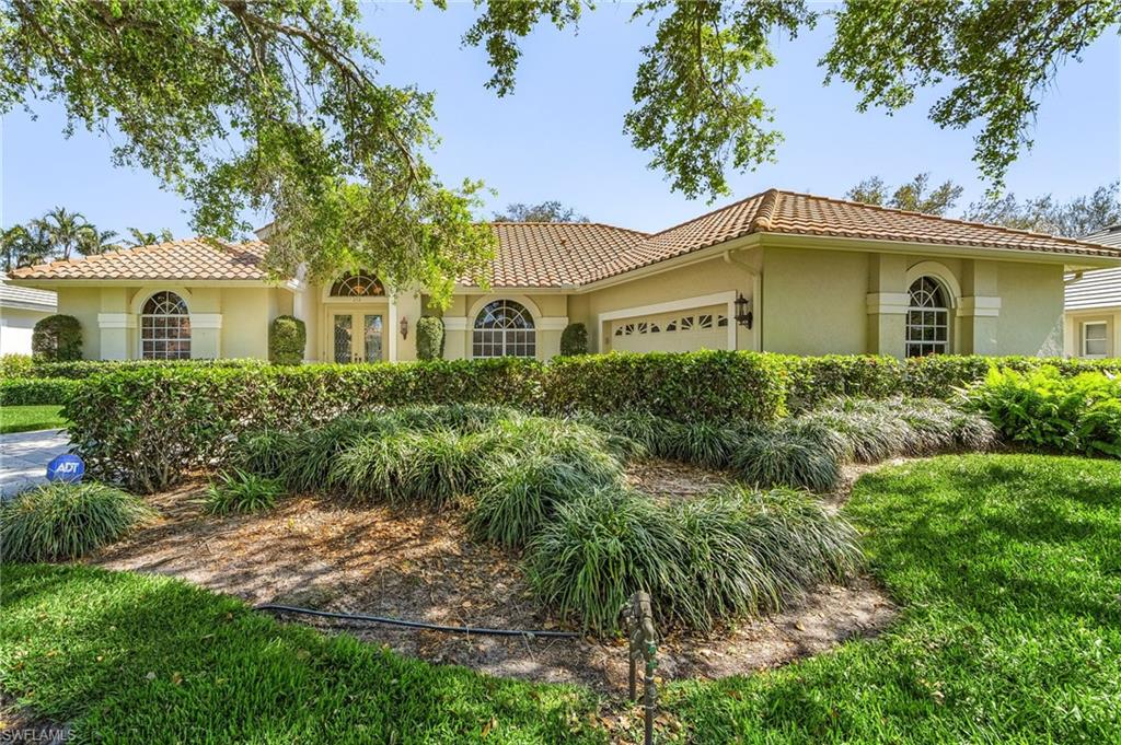 258 Monterey Drive Naples, FL 34119 - Photo 26 of 36 a front view of a house with a yard and potted plants