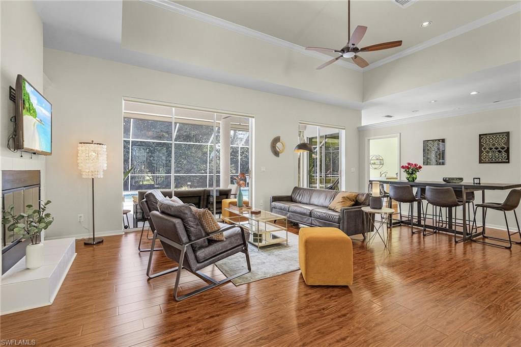 258 Monterey Drive Naples, FL 34119 - Photo 5 of 36 a living room with furniture wooden floor and a floor to ceiling window