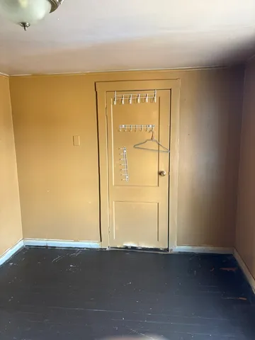 a view of a room with wooden floor and a window
