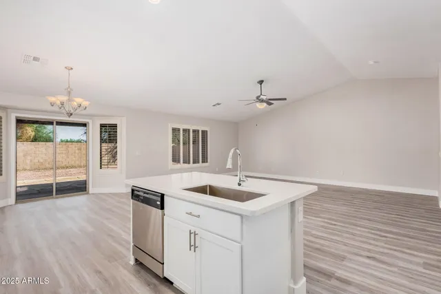 a kitchen with a sink cabinets and wooden floor