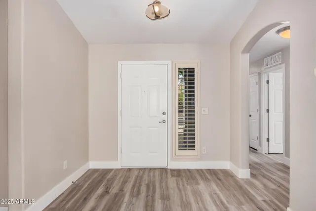 a view of an empty room with closet and a window