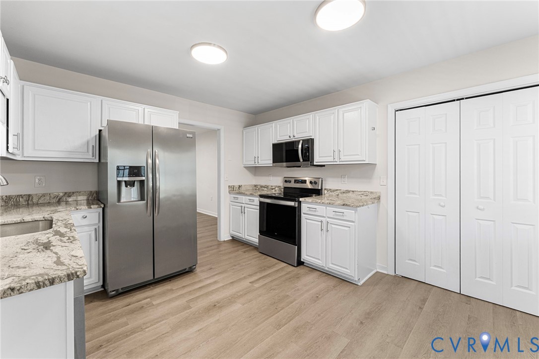 1146 Indian Valley Road Heathsville, VA 22473 - Photo 6 of 45 a kitchen with a refrigerator stove and white cabinets
