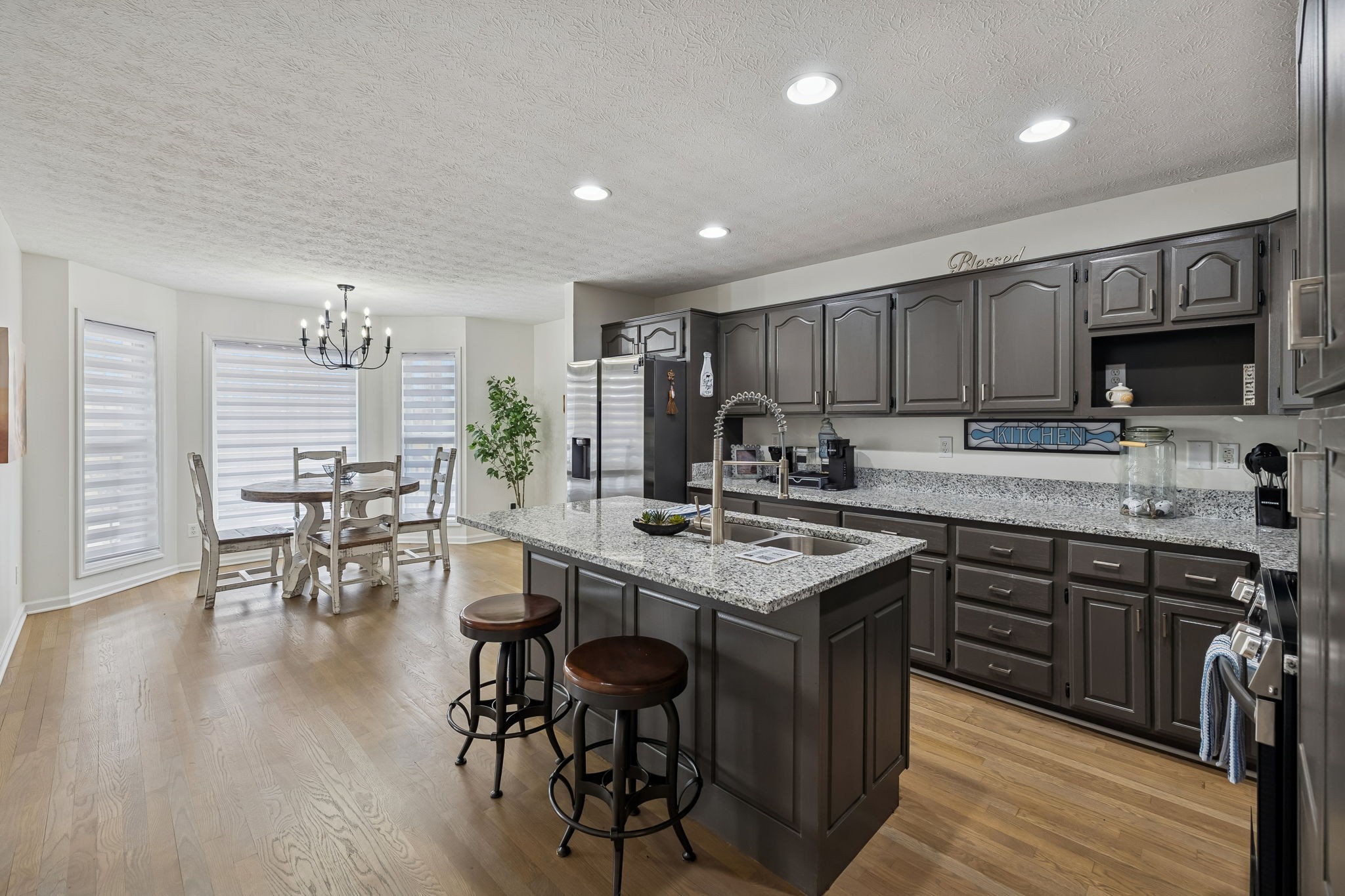814 Denning Ford Road Portland, TN 37148 - Photo 20 of 99 a kitchen with stainless steel appliances granite countertop a stove top oven a sink dishwasher a dining table and chairs with wooden floor
