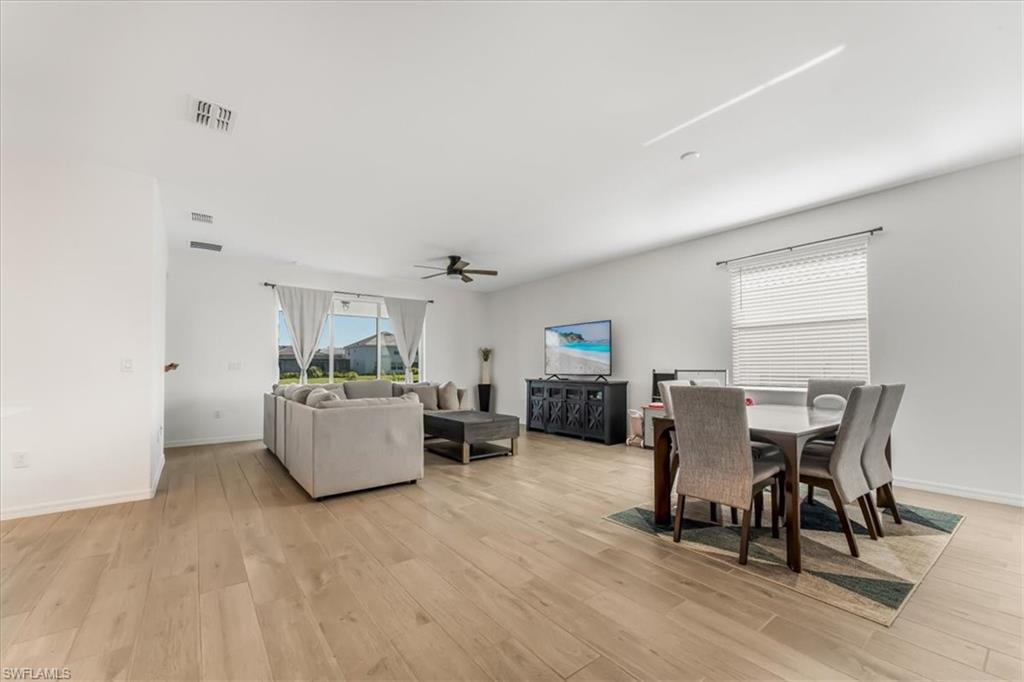2581 Kona Way Naples, FL 34120 - Photo 7 of 35 a view of a dining room with furniture and wooden floor