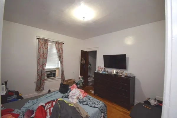 a bedroom with bed and a wooden floor