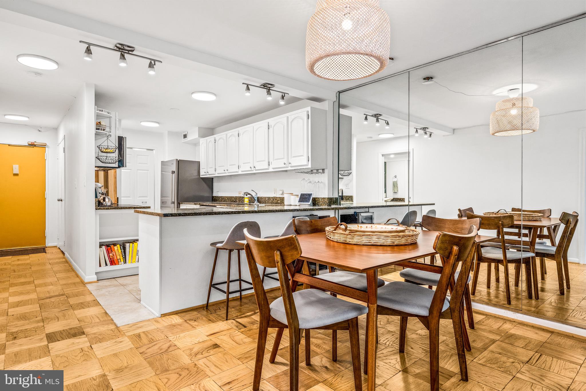 1001 26th Street Northwest, Unit 306 Washington, DC 20037 - Photo 4 of 22 a dining area with a table chairs and a kitchen view