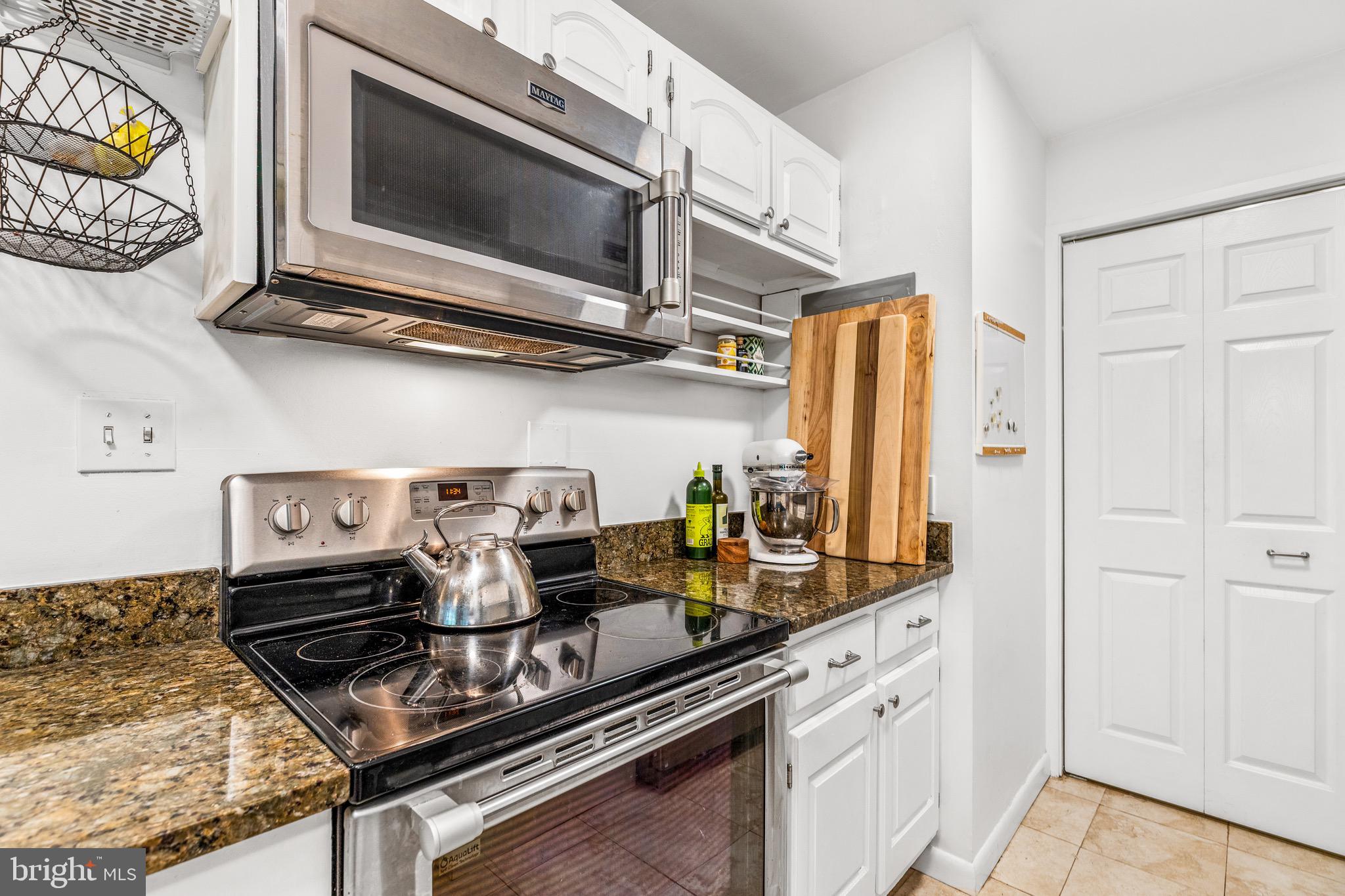 1001 26th Street Northwest, Unit 306 Washington, DC 20037 - Photo 7 of 22 a kitchen with stainless steel appliances granite countertop a stove and a microwave