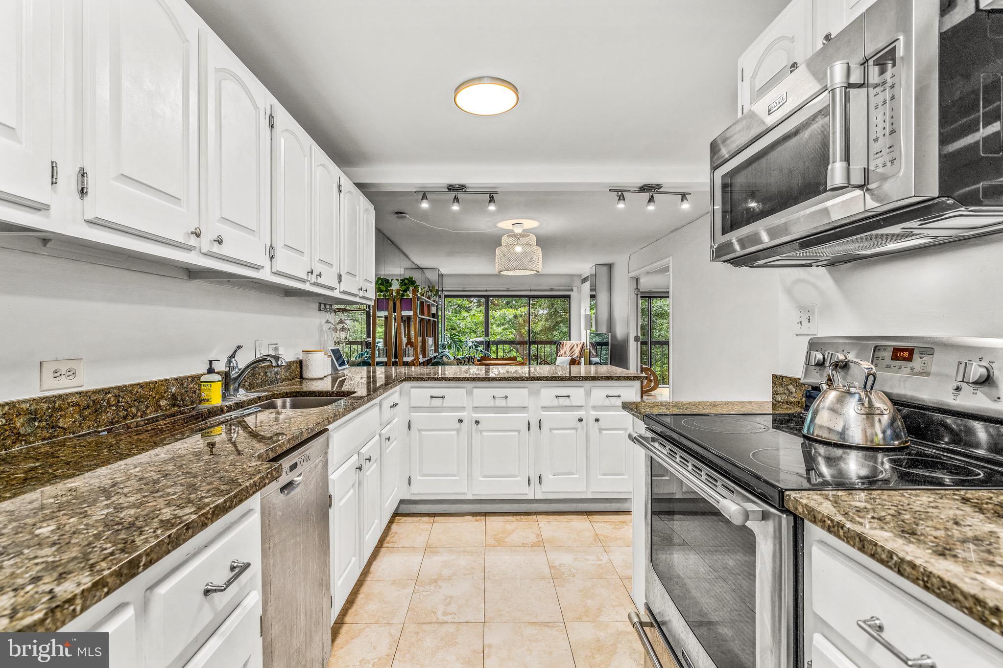 1001 26th Street Northwest, Unit 306 Washington, DC 20037 - Photo 10 of 22 a kitchen with stainless steel appliances granite countertop a sink stove and cabinets