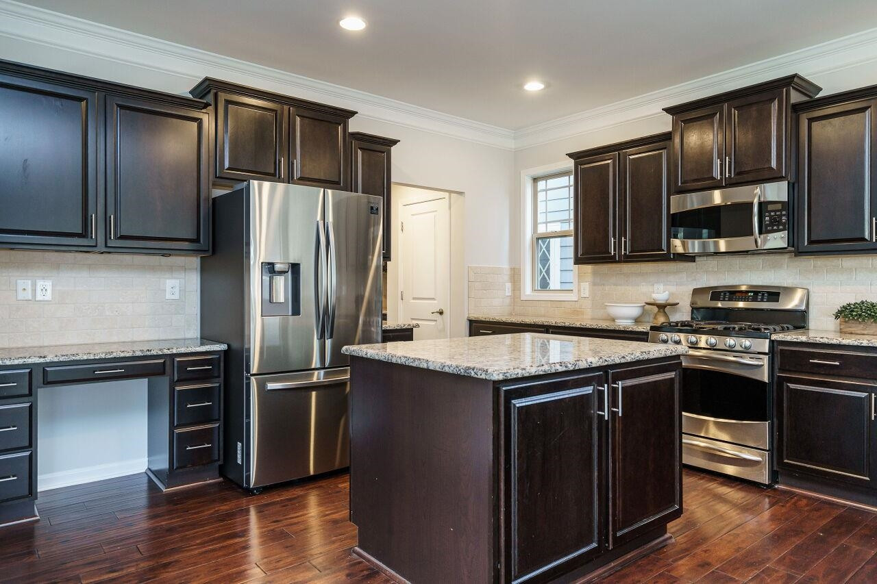 1340 Rodessa Run Raleigh, NC 27607 - Photo 5 of 29 Kitchen includes refrigerator, gas range, desk, island, granite, all stainless appliances! Kitchen