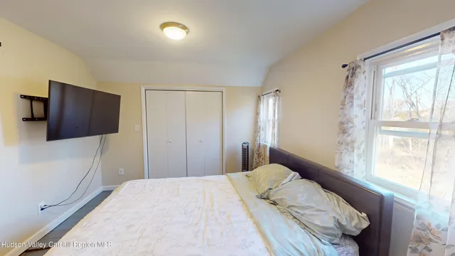a bedroom with a large bed and a flat tv screen