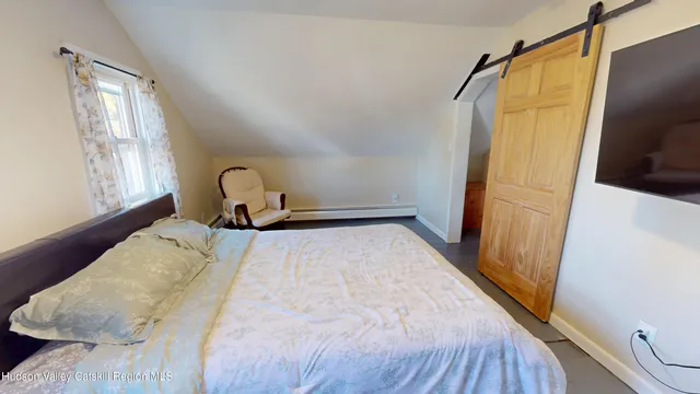 a bedroom with a bed and a window with the outer view