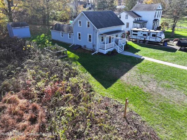 a view of a house with a big yard and large trees
