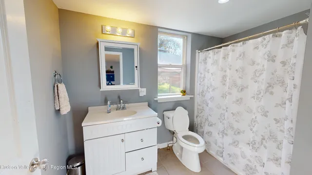 a bathroom with a sink toilet and window