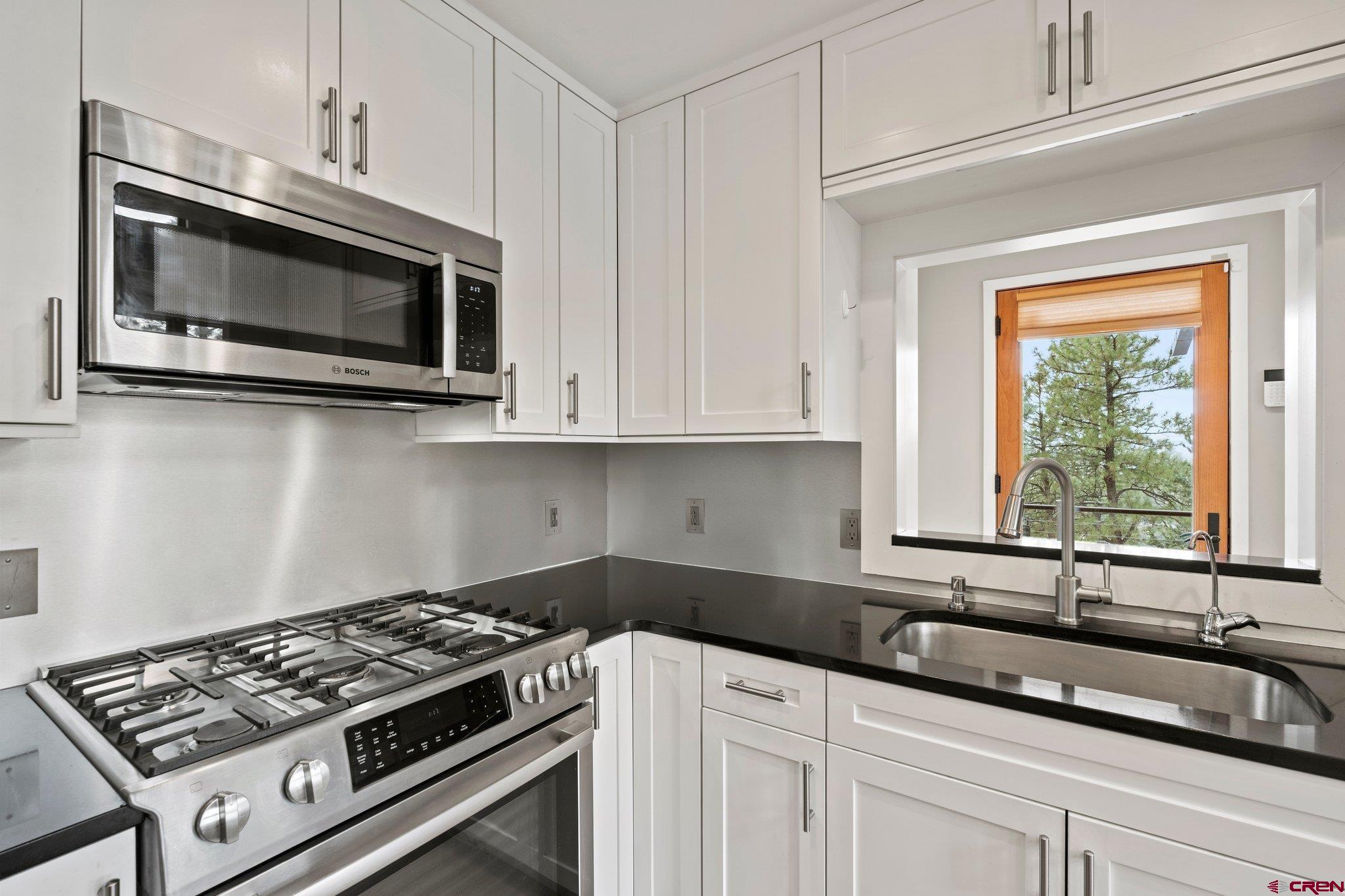 855 Ridge Road Durango, CO 81303 - Photo 9 of 35 a kitchen with granite countertop white cabinets stainless steel appliances and a sink