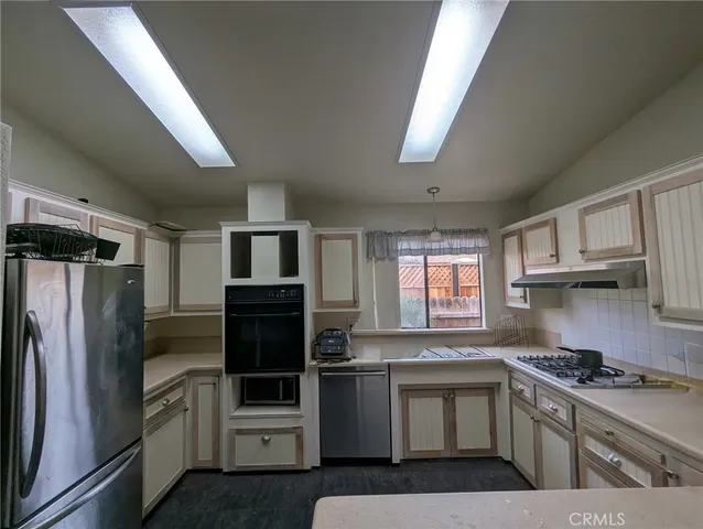 a kitchen with stainless steel appliances granite countertop a refrigerator stove and sink