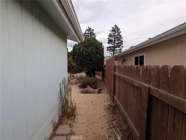 a view of a pathway of a house with wooden fence