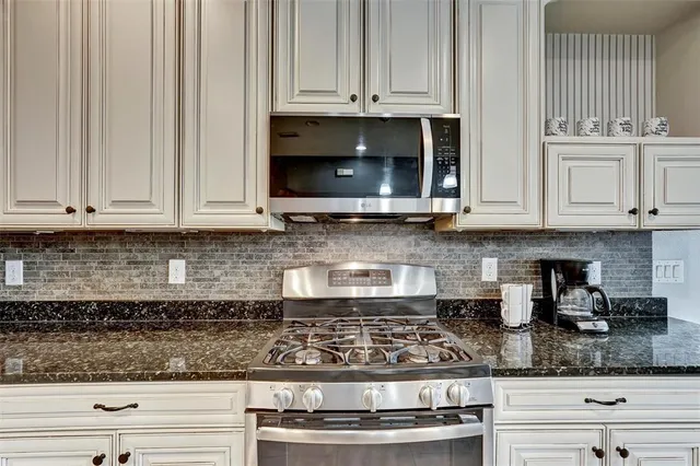 a kitchen with stainless steel appliances granite countertop white cabinets and granite counter tops