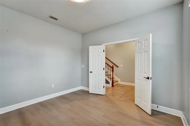 an empty room with a white cabinet and wooden door