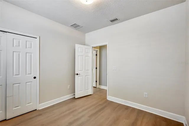 a view of an empty room with wooden floor