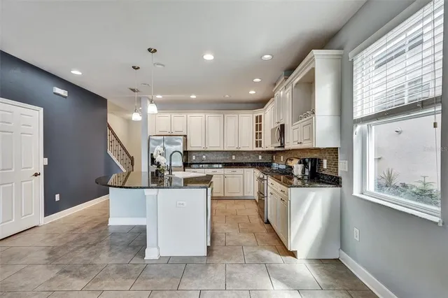 a kitchen with stainless steel appliances granite countertop a refrigerator a sink and a stove