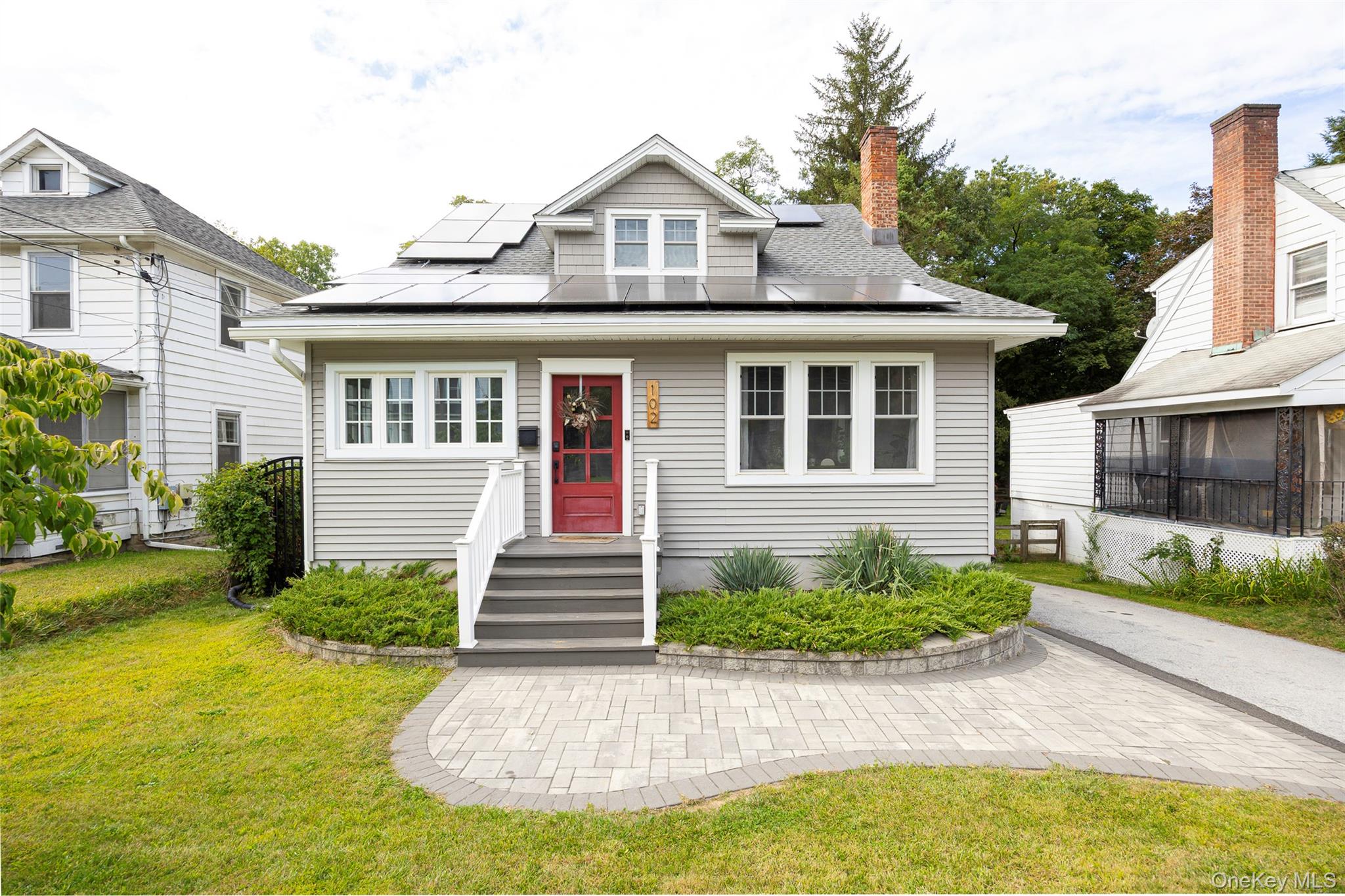 102 Innis Avenue Poughkeepsie, NY 12601 - Photo 1 of 1 View of front facade with solar panels, a chimney, and a front lawn