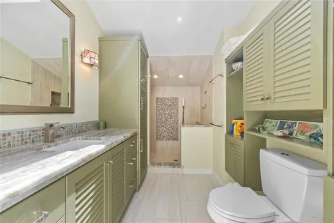 a bathroom with a granite countertop sink toilet and shower