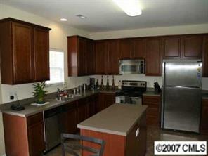 10516 Little Whiteoak Road Charlotte, NC 28215 - Photo 2 of 8 a kitchen with a refrigerator and a stove top oven