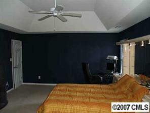 10516 Little Whiteoak Road Charlotte, NC 28215 - Photo 6 of 8 a bedroom with a bed and a chandelier