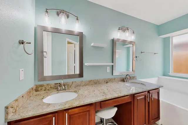 a bathroom with a granite countertop sink a mirror and a vanity