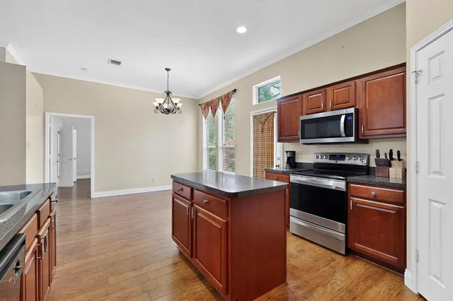 a kitchen with granite countertop a stove top oven and refrigerator