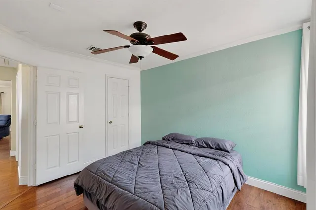 a bedroom with a bed and a ceiling fan