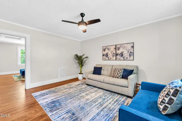 a living room with furniture and wooden floor