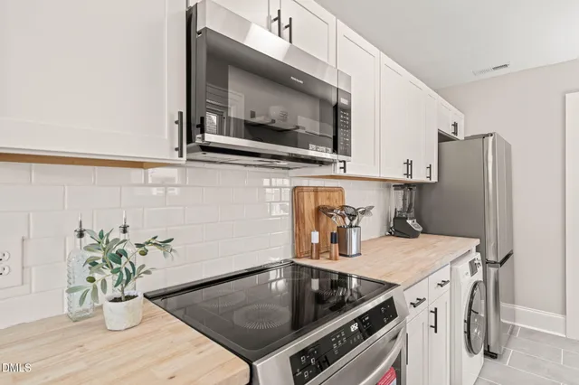 a kitchen with stainless steel appliances a stove a microwave a sink and cabinets