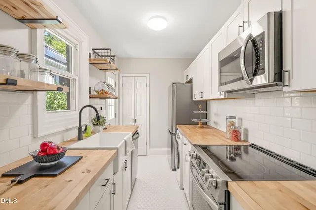 a kitchen with stainless steel appliances granite countertop a sink stove and cabinets