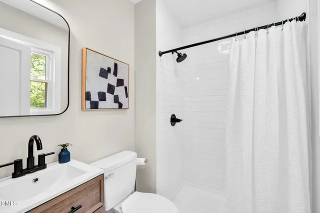 a bathroom with a sink vanity mirror and toilet