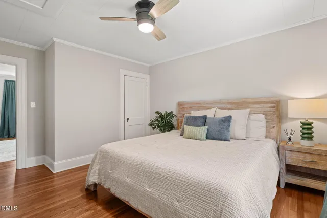 a bedroom with a large bed and wooden floor